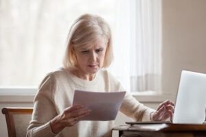 frustrated middle aged woman looking at medical bills
