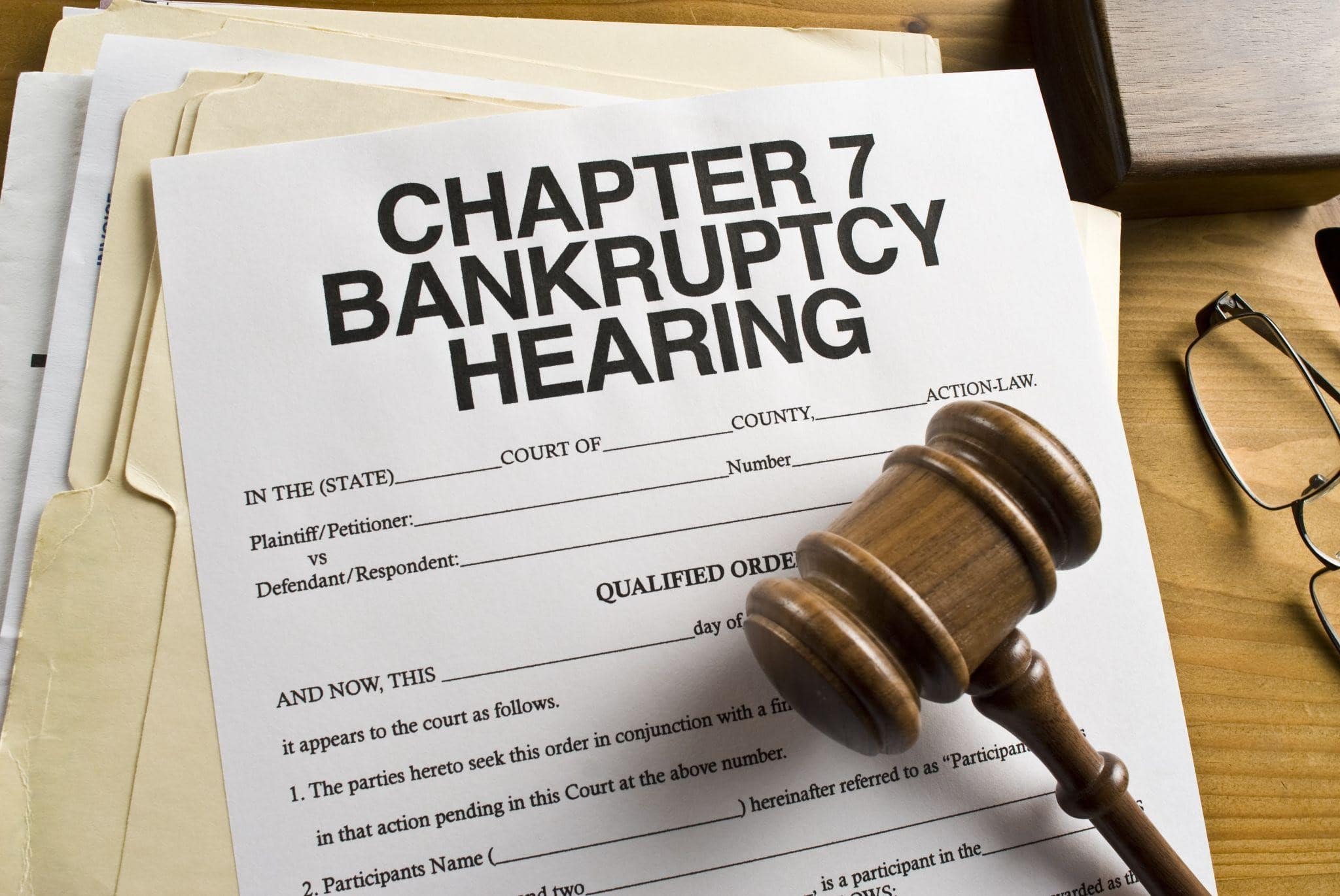 paper with text saying chapter bankruptcy hearing on it and a gavel laying on top of the paper