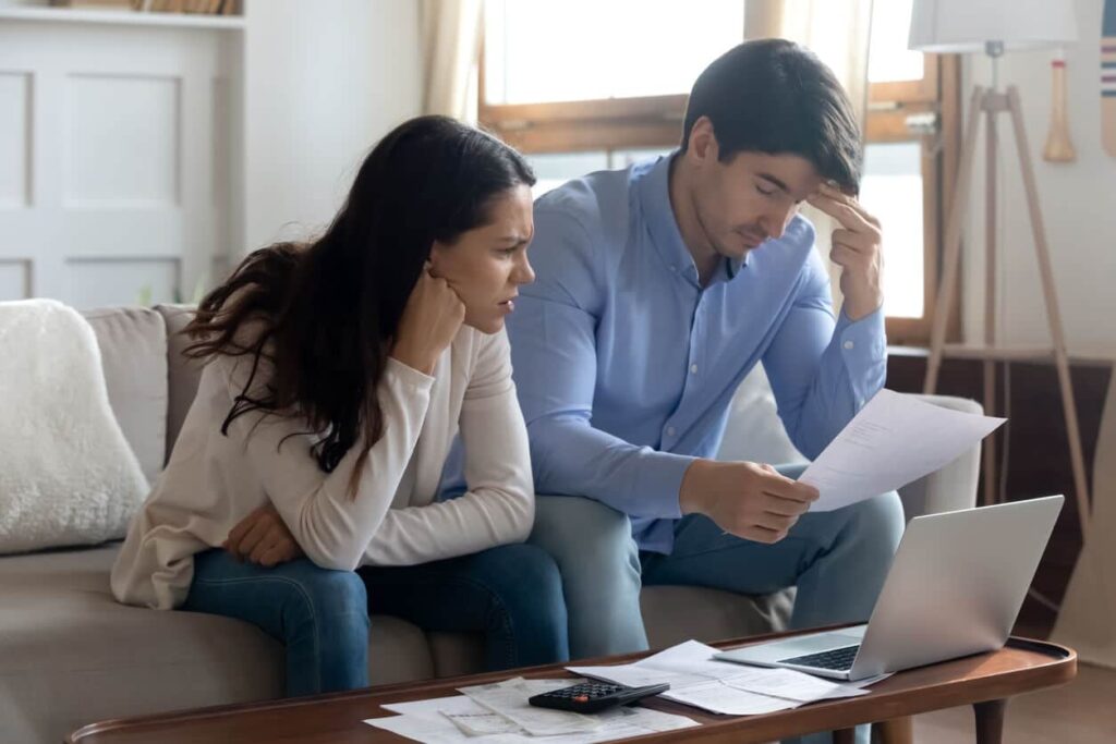 Stressed couple reviewing bills and paperwork